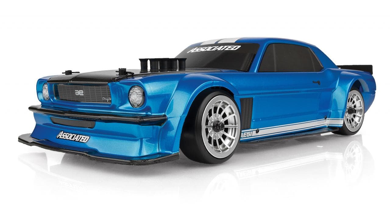 A Team Associated DC10 ready-to-run drift car from the front three-quarter: a blue classic-coupe body with white stripes, a carbon-look hood and splitter, and silver multi-spoke wheels, on a white background.